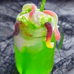 63119662 - green drink with ice cream float and jelly worms for halloween
